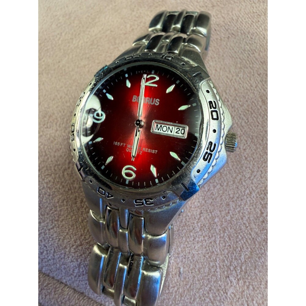Vintage Benrus dive-style watch featuring a red dial and a stainless steel band